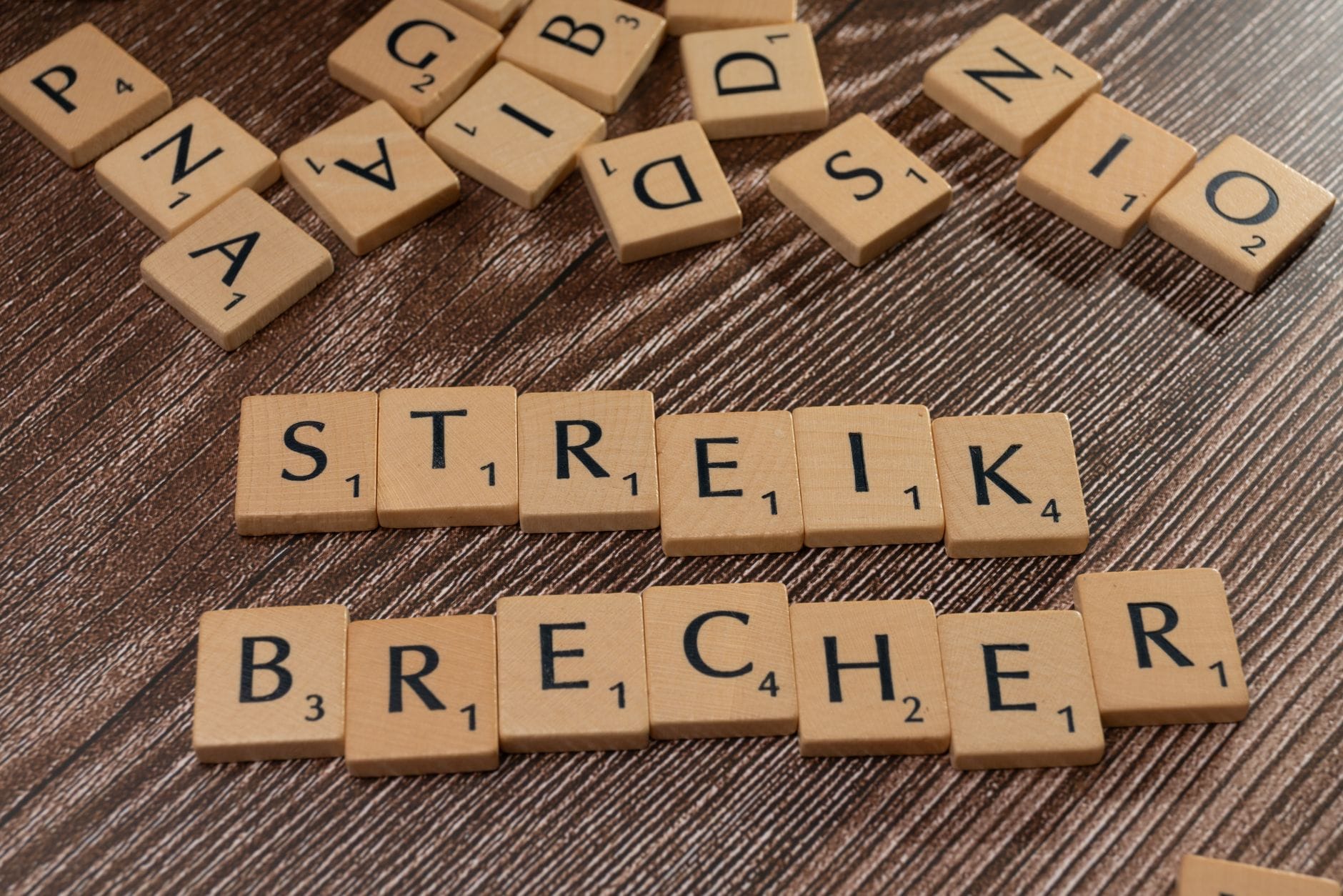 Drewniane płytki Scrabble tworzą niemiecki napis Streikbrecher
