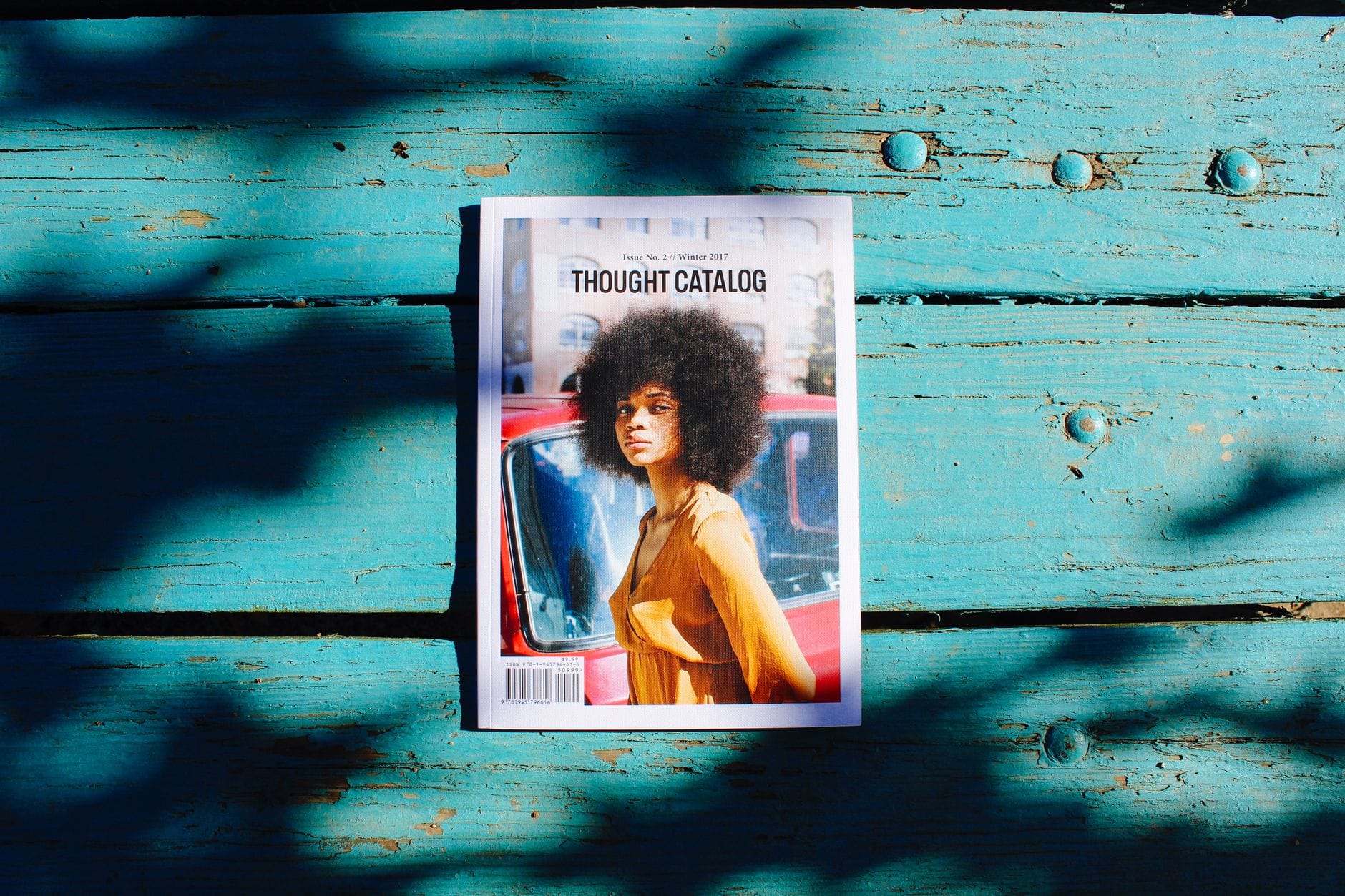 Magazyn Thought Catalog z elegancką okładką na drewnianej powierzchni